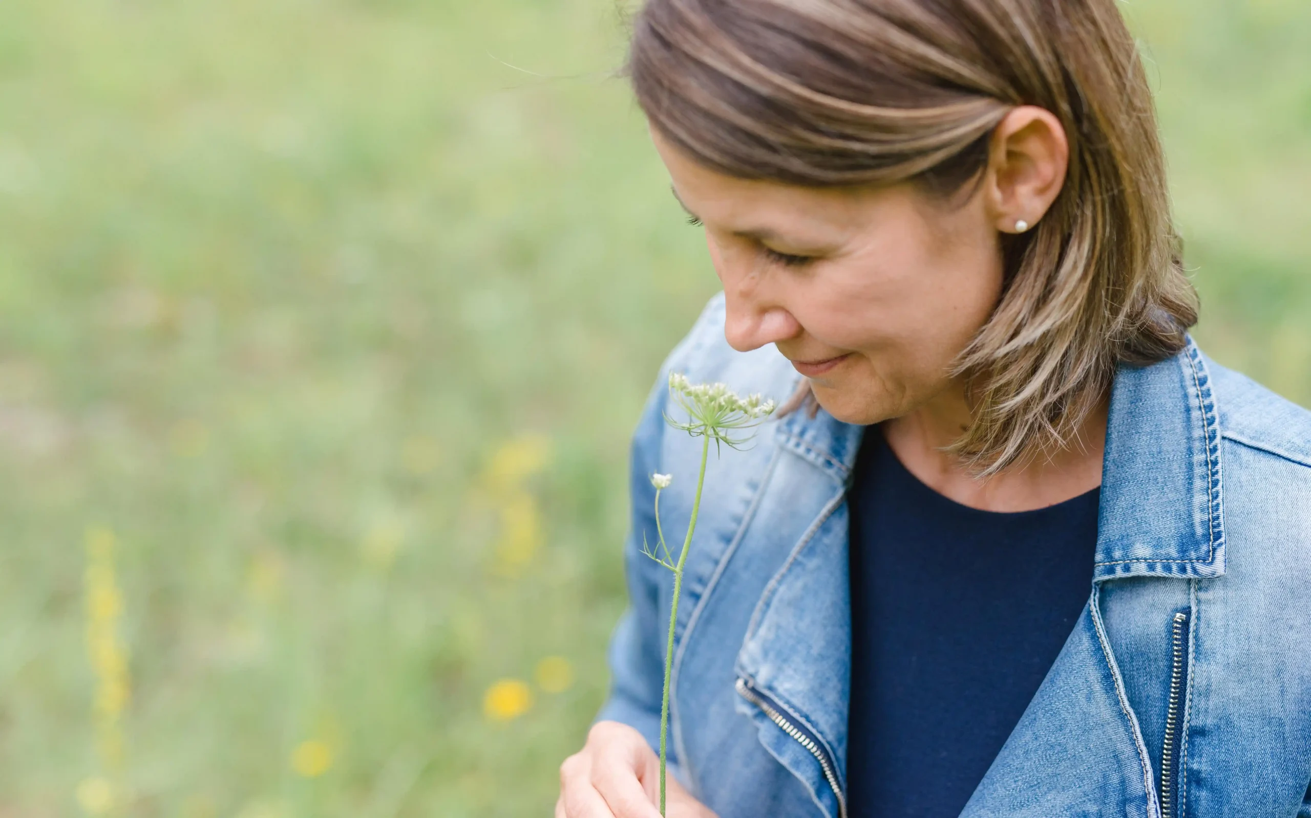 Frau riecht an Blume