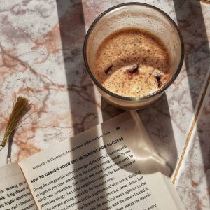 Tasse mit Kaffe steht neben einem Buch zum Thema Gewohnheiten verändern