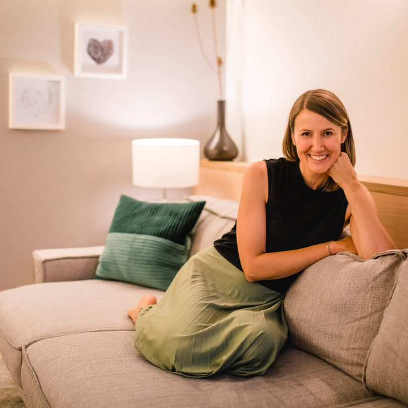 Carmen sitzt auf der Couch zugeschnitten Frau sitzt auf einer Couch im Wohnzimmer
